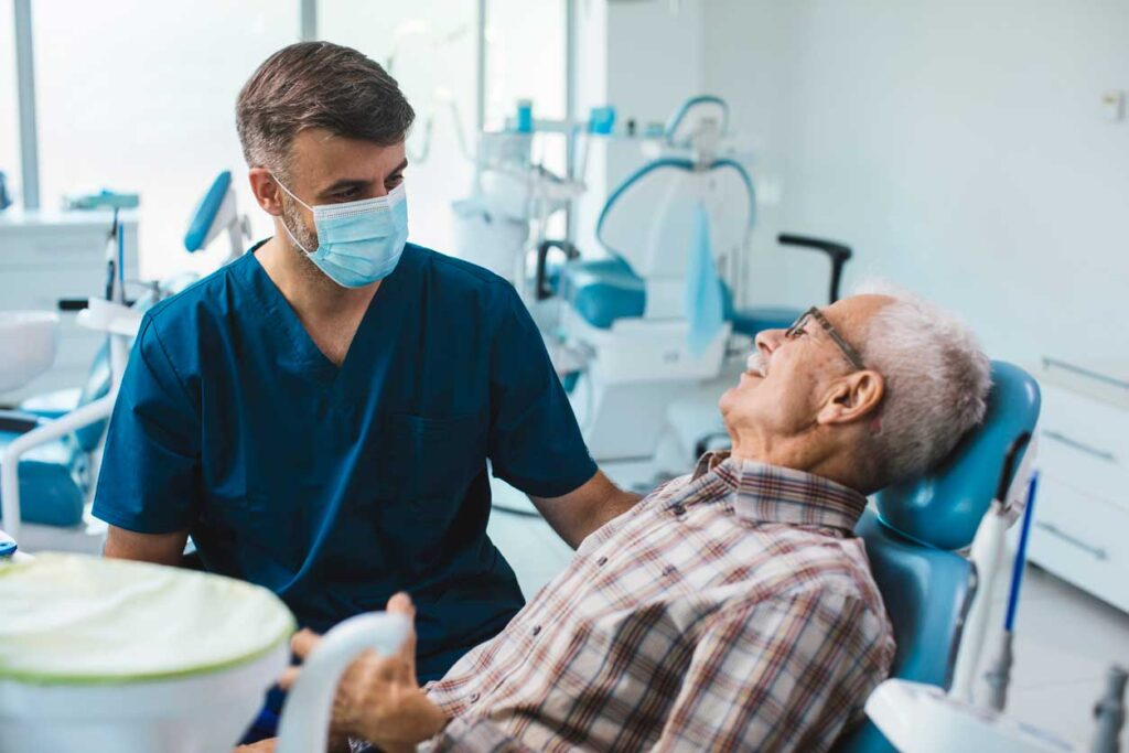 Dentist talking to a patient in a dental chair.